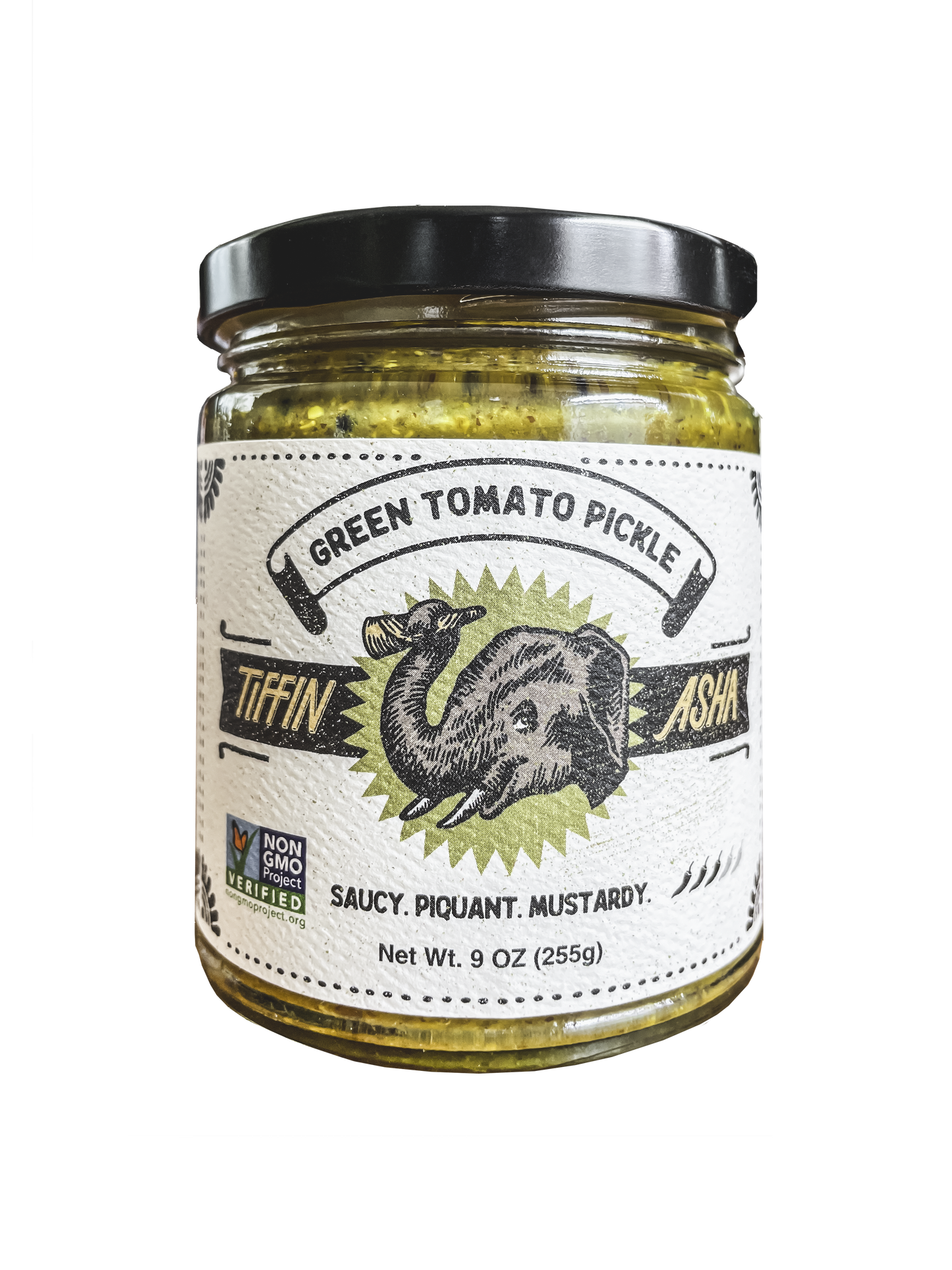 9 oz glass jar with black lid. Label reads: Tiffin Asha, with an elephant head and its trunk holding a dosa, green tomato pickle, NON GMO project VERIFIED, tasting notes read: saucy, piquant, mustardy, shows 3 chili peppers for heat level.